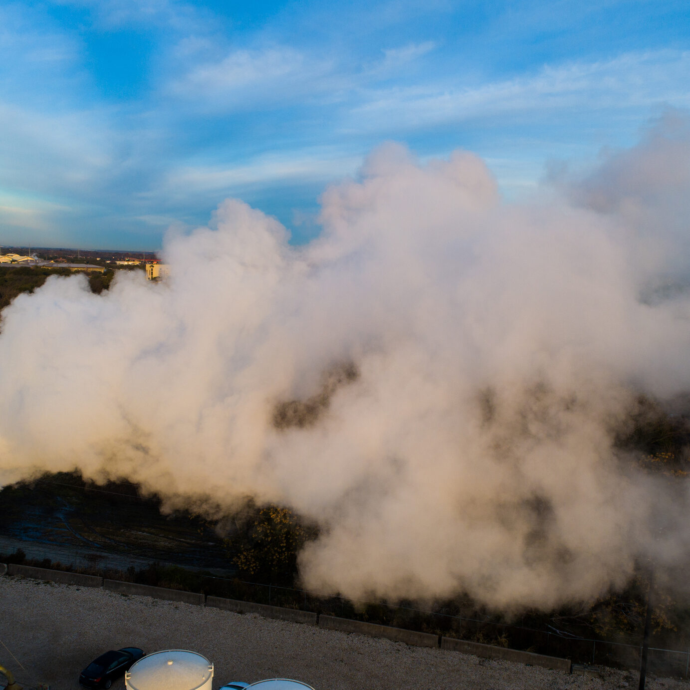 Aerial drone view above industrial pipe refinery factory smog smoke stack releasing large clouds into the atmosphere. Global warming and climate change