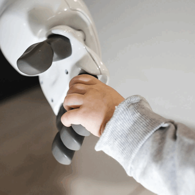 a child holding a robotic hand